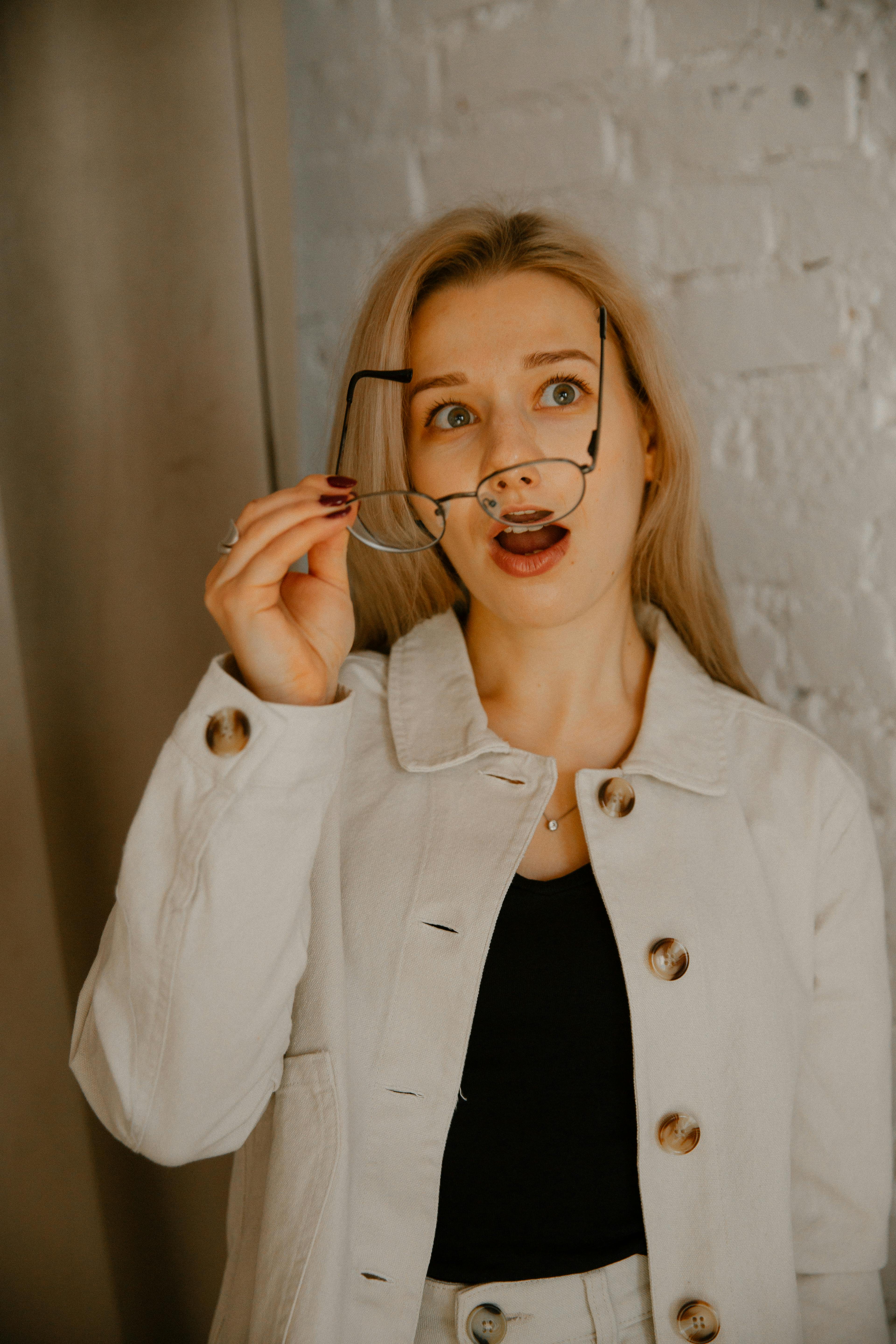 Shocked woman holding a pair of eyeglasses | Source: Pexels