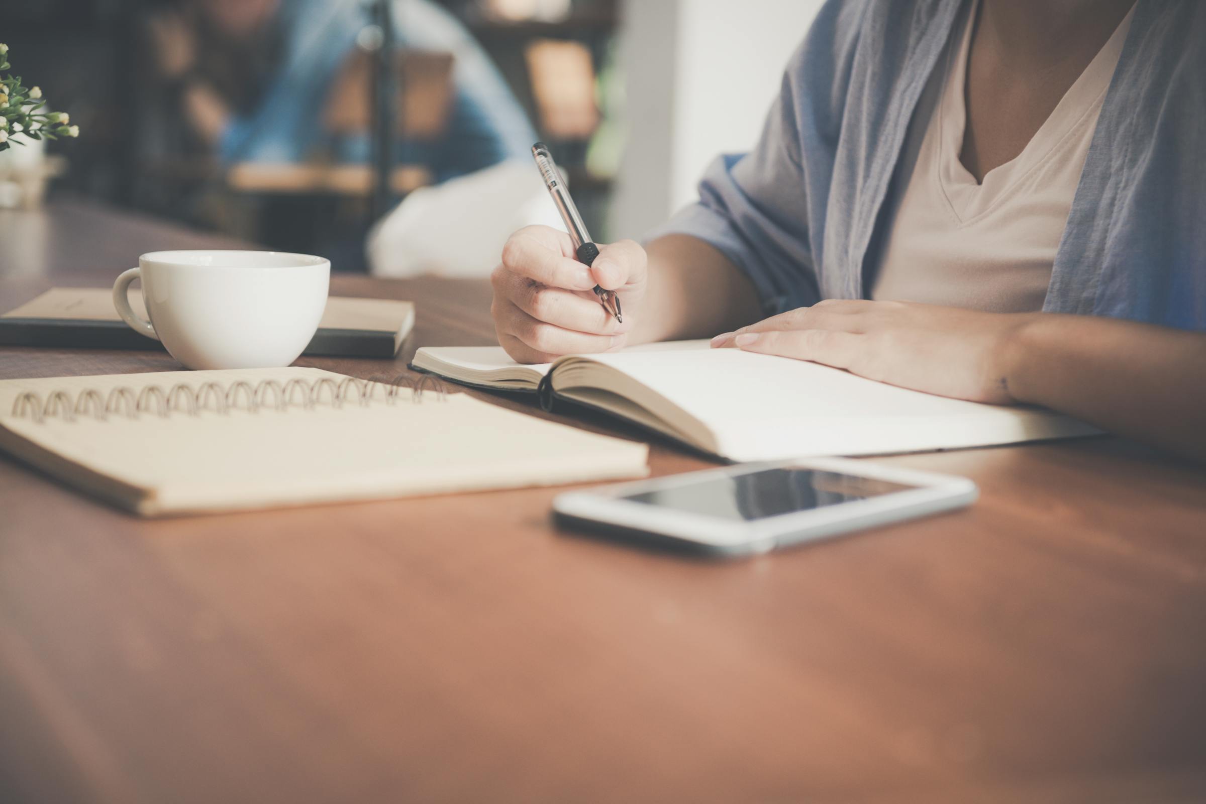 A young woman writing on a notebook | Source: Pexels